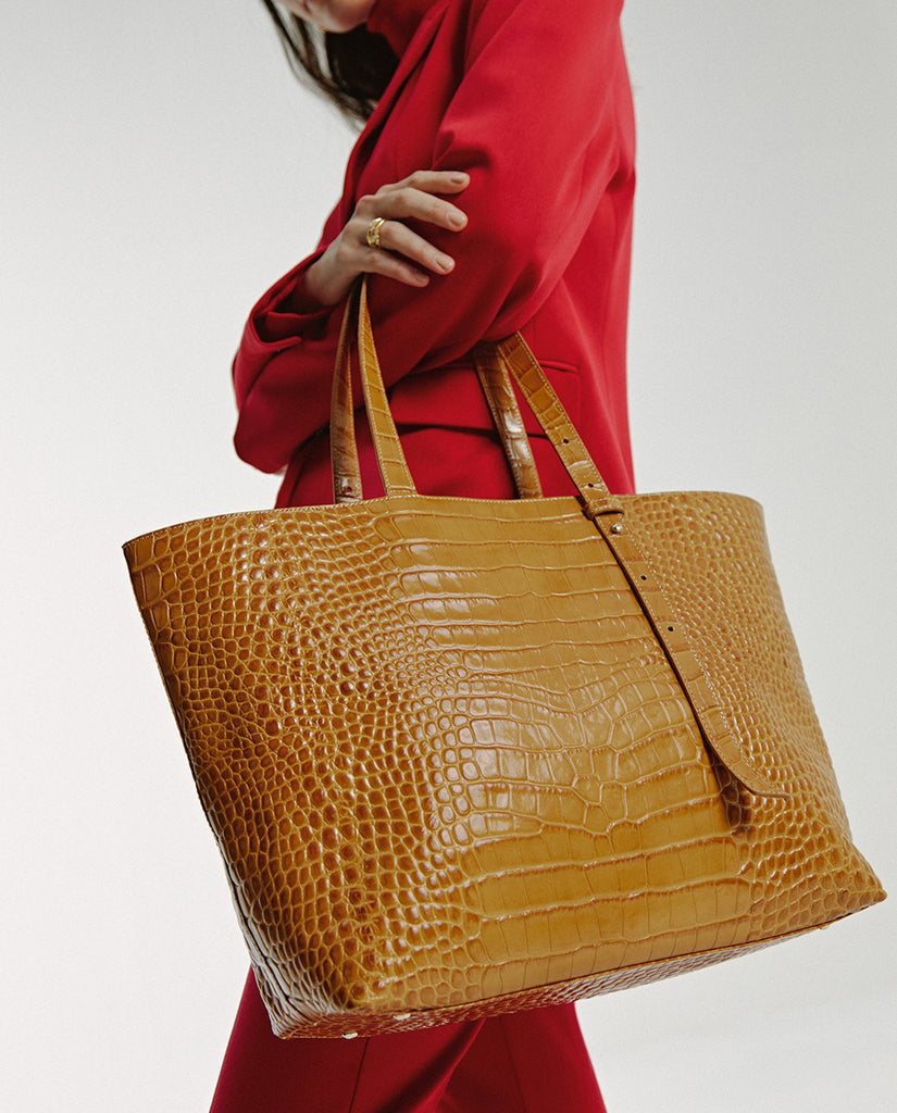 Imagen de modelo con bolso de hombro tipo shopping bag de piel grabada en coco color camel Leandra made in Spain 